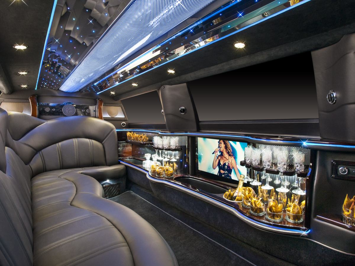 Lit interior of the Lincoln MKT stretch limousine, wraparound leather seating, bar and entertainment screen