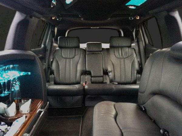 Rear passenger cabin of the Lincoln MKT stretch limousine, black leather seating and bar
