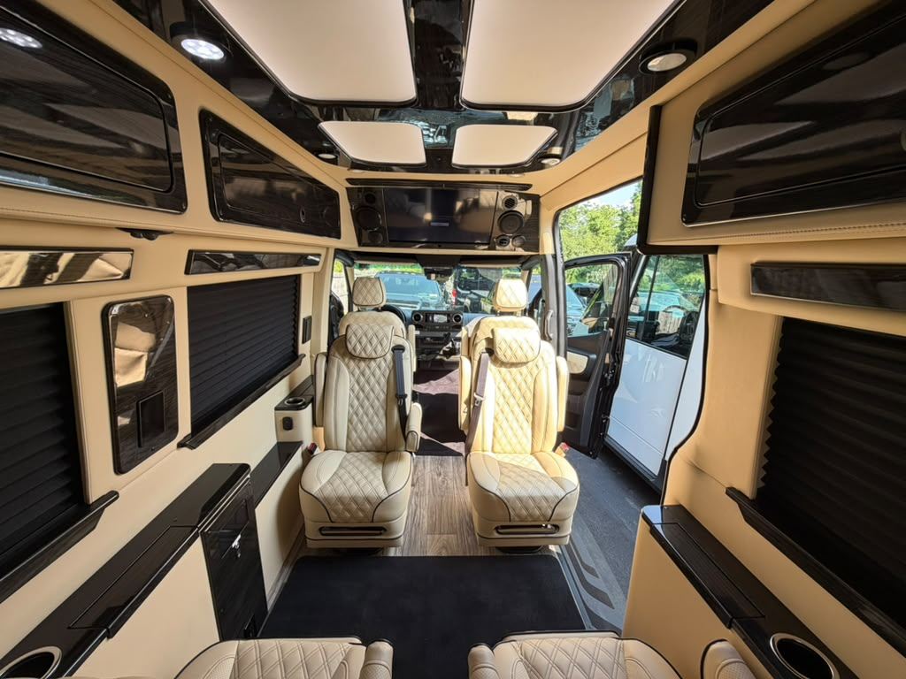 Cream quilted leather captain’s chairs inside the Mercedes-Benz Sprinter executive coach