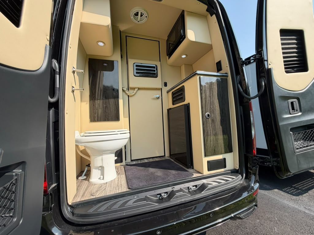 Rear doors open showing the onboard restroom in the Mercedes-Benz Sprinter