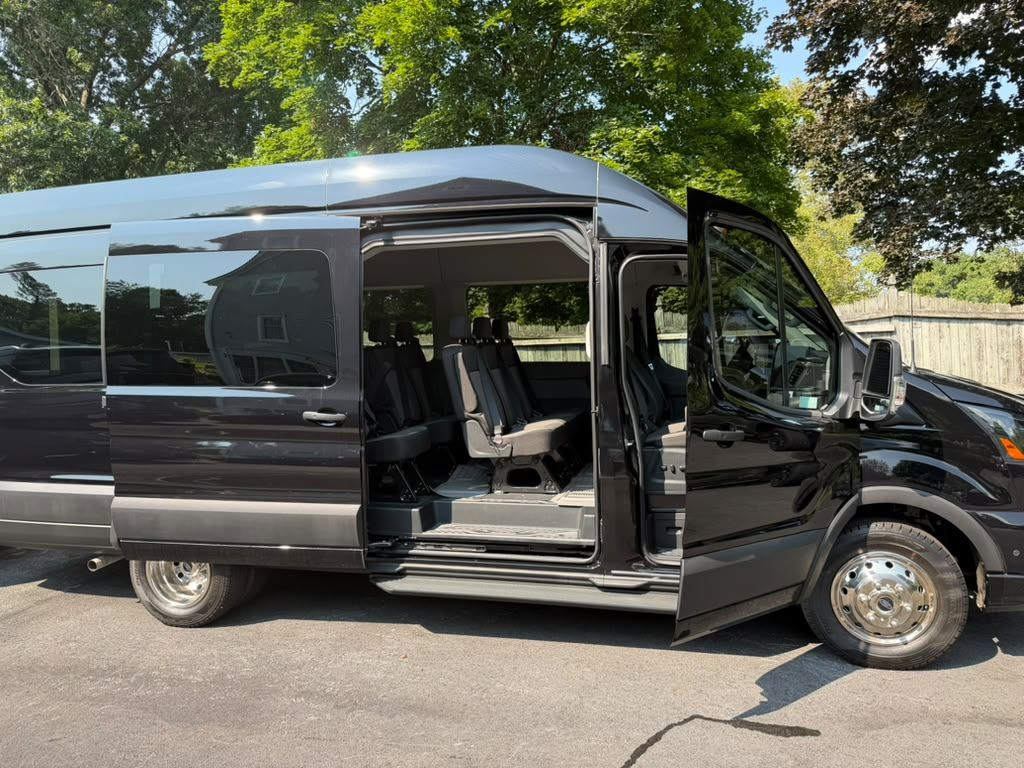 Black Ford Transit high-roof shuttle van with the side door open — Orange County Limousine